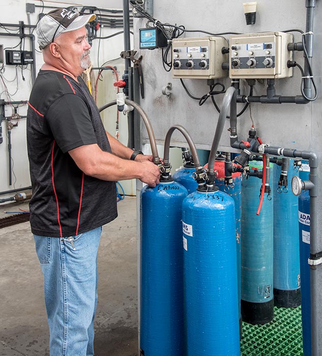 Water Treatment Services | Man standing beside tanks