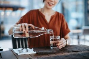 A Lady Pouring Water into a Glass | Purify Water