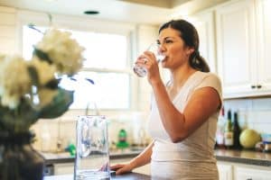 A Woman Drinking a Glass of Water | Water Filtration System Cost