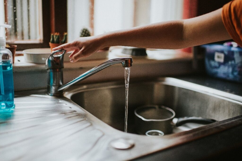 A Person Running Water From a Tap | Water Problems