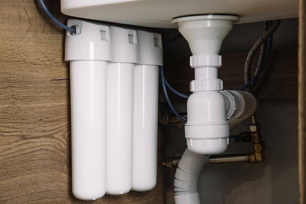 Best water filter for rental installation, showing a non-permanent reverse osmosis or multi-stage filter attached to plumbing.